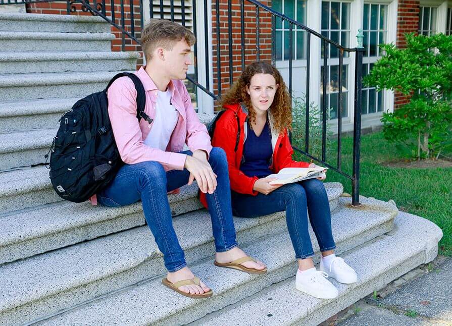 Two young college students sit and chat