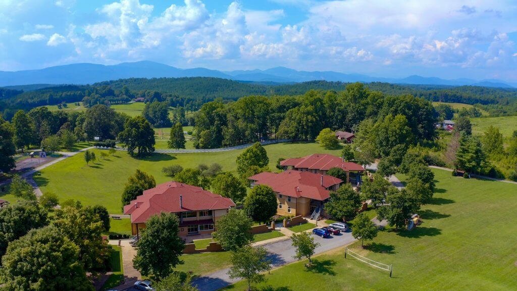 CooperRiis residential mental health recovery campus as seen from above with rolling hills and Blue Ridge mountains on the horizon