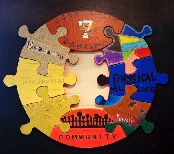 a wooden puzzle showing the seven domains of a whole, healthy person