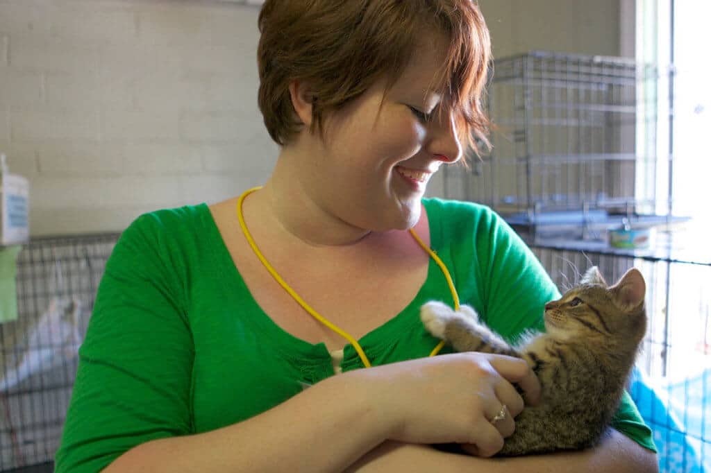 Woman smiles and holds an adorable kitten at CooperRiis, which offers residential treatment of personality disorders and other mental health conditions