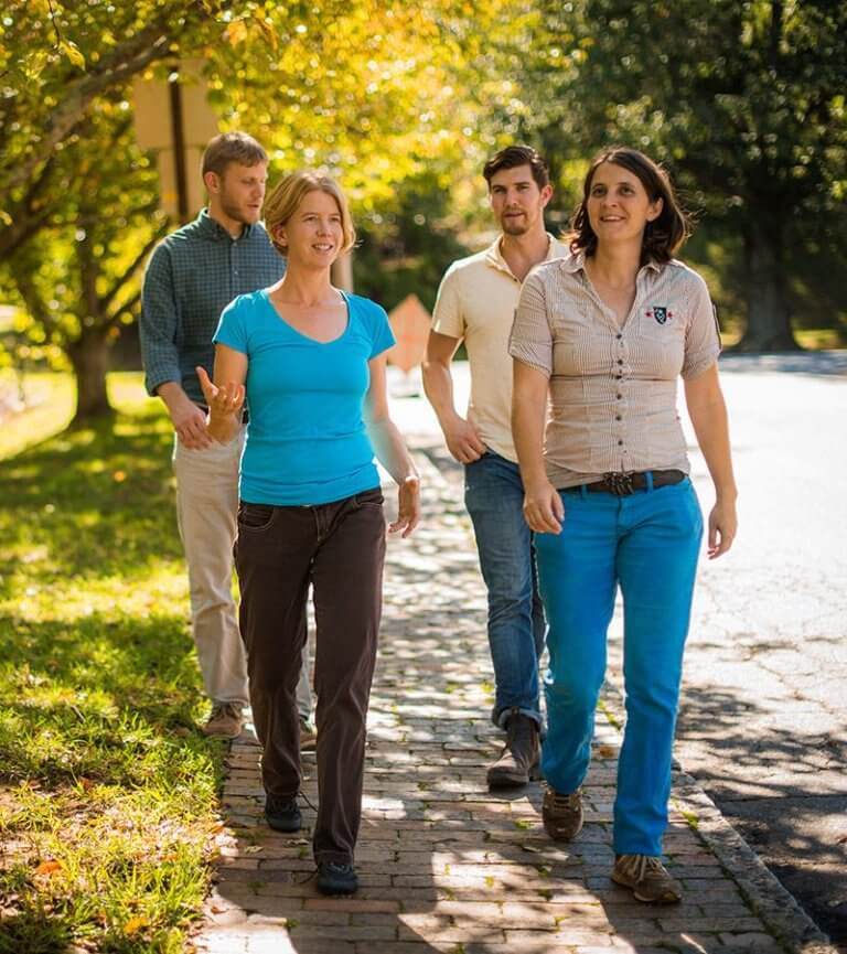 A group of young people talk while walking through the Montford neighborhood of Asheville in the autumn