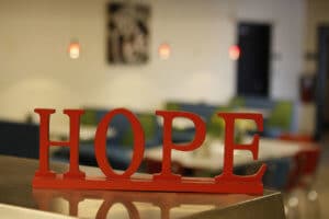 A red wooden sign reading Hope sits on a counter