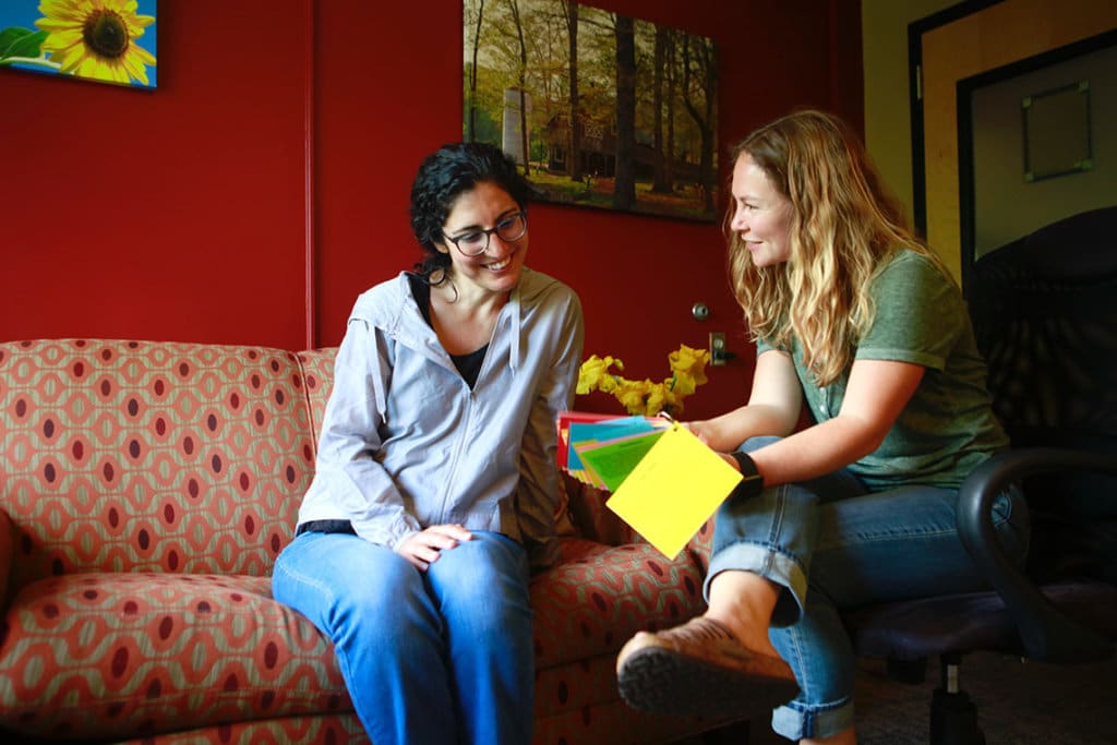 two women looking at colored cards together