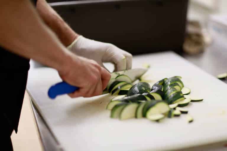 hands chopping zucchini