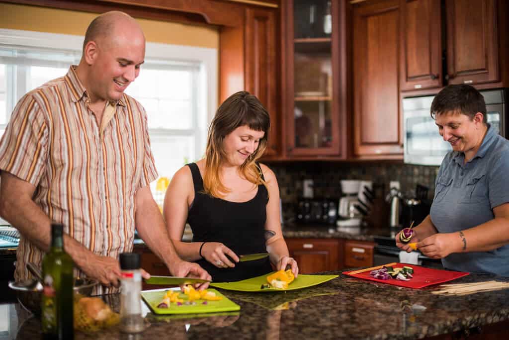 people in kitchen cutting veggies