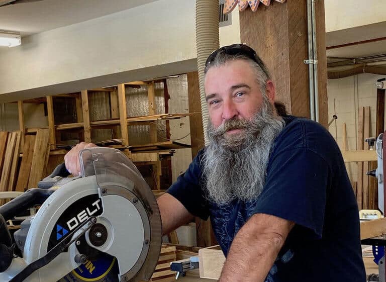Woodshop technician stands by table saw