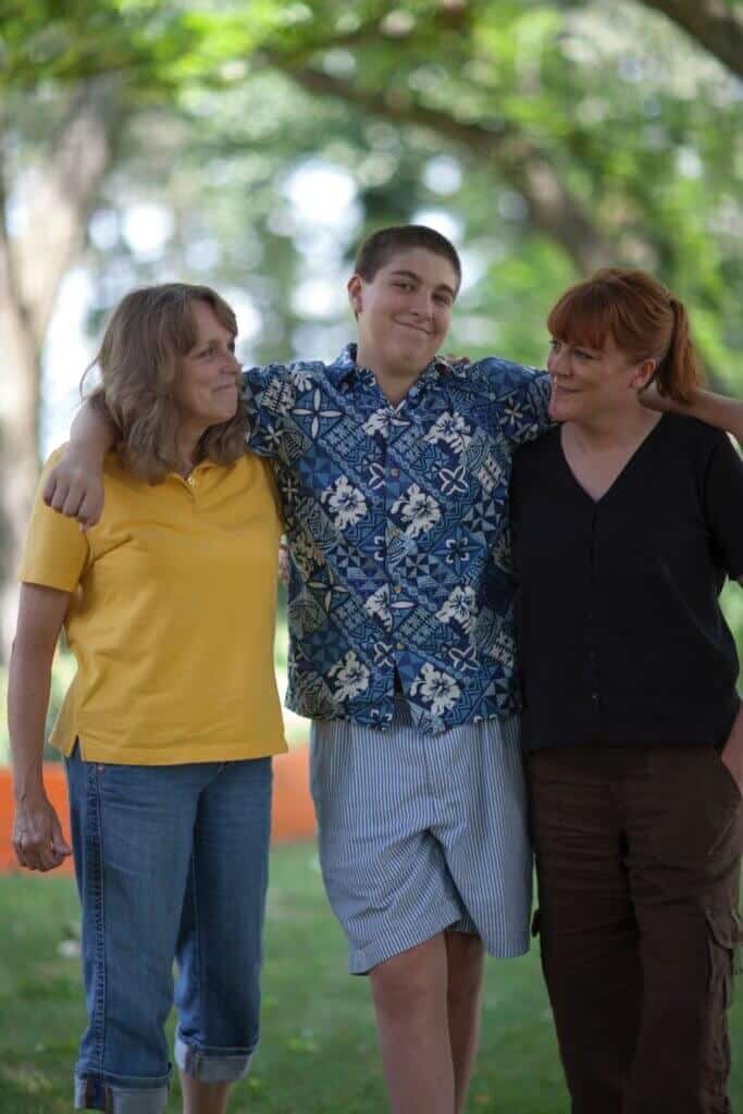 trio walking together arms around each other