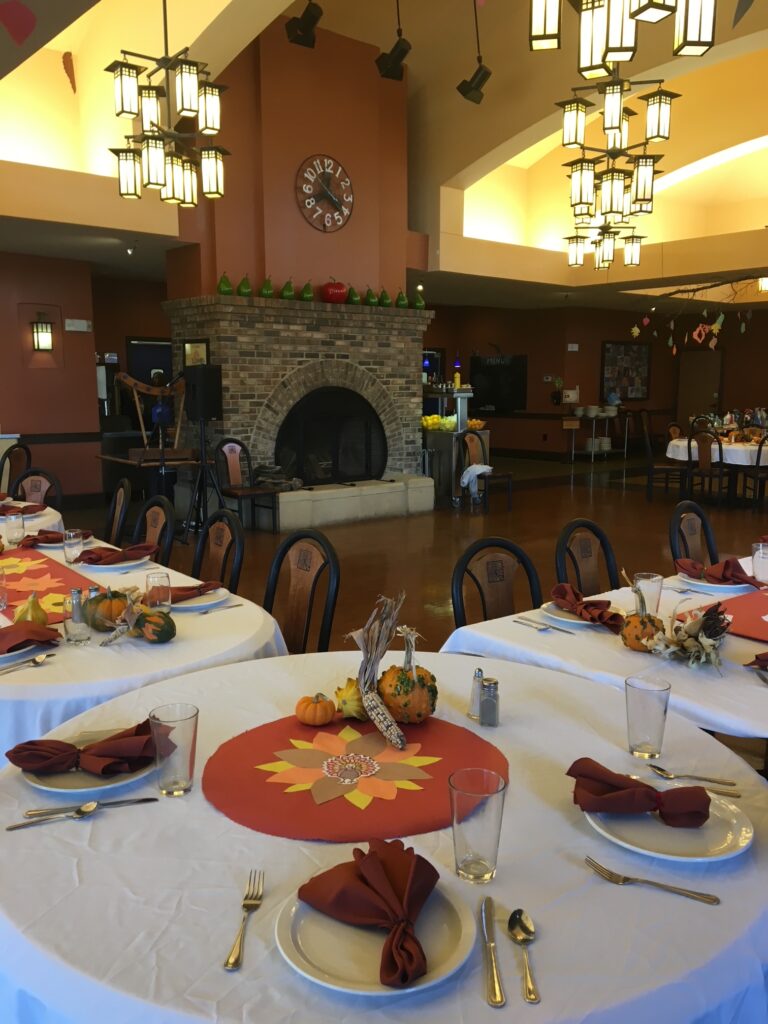 Large, cozy dining room at CooperRiis arranged for Thanksgiving dinner to show what it's like on holidays in residential treatment.